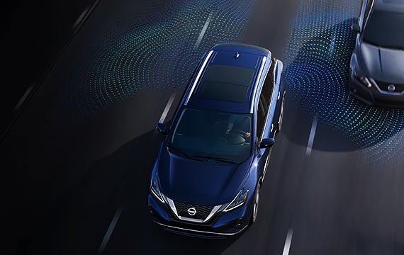 Nissan sedan using advanced driver-assistance technology on a highway.