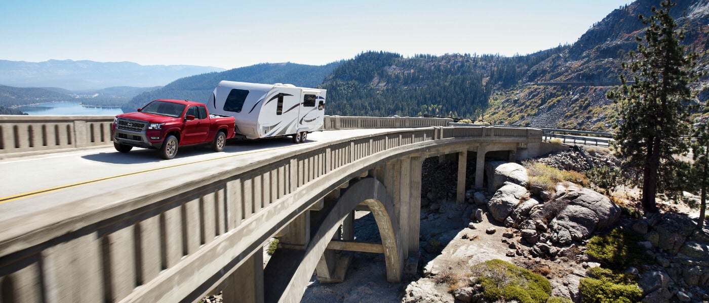 2025 Nissan Frontier towing a camper on a bridge