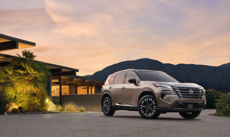 2025 Nissan Rogue parked by a home at sunset